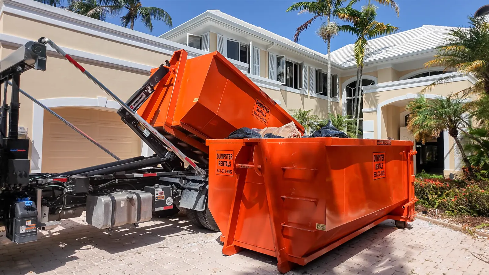 Sabatello truck swapping two 16-yard dumpsters on a tight residential job site